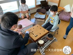 関達也プロの囲碁講座と指導碁会の様子